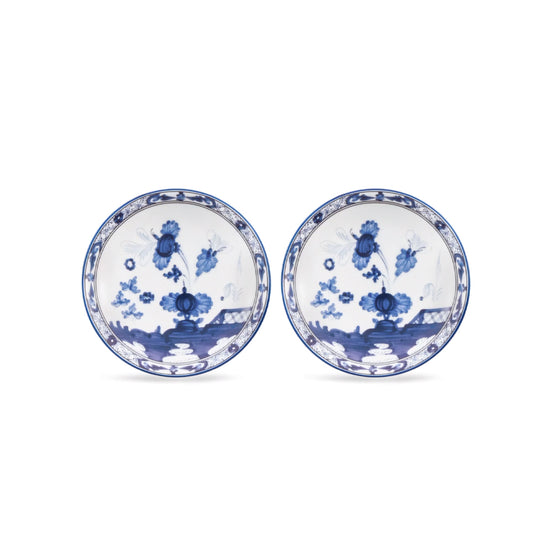 Two round white porcelain plates with blue floral and landscape illustrations, displayed side by side on a white background.
