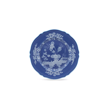 A blue ceramic plate with a white hand-painted chinoiserie floral and landscape design, centered on a plain white background.