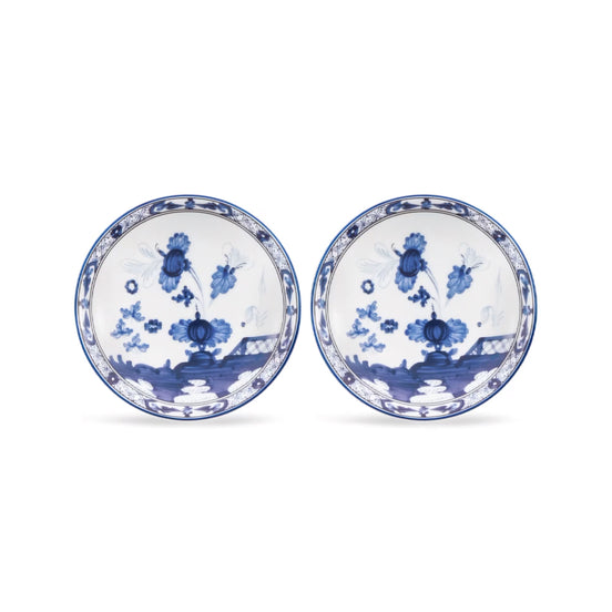 Two round white porcelain plates with blue floral and landscape illustrations, displayed side by side on a white background.