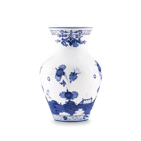 A classic blue and white porcelain vase featuring hand-painted floral motifs and a landscape scene near the base, set against a plain white background.