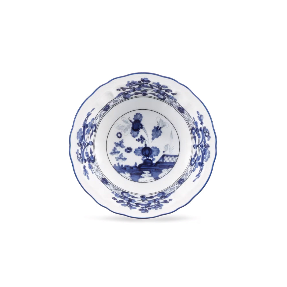 A white ceramic bowl with a blue floral and landscape pattern, photographed from directly above on a clean white background.