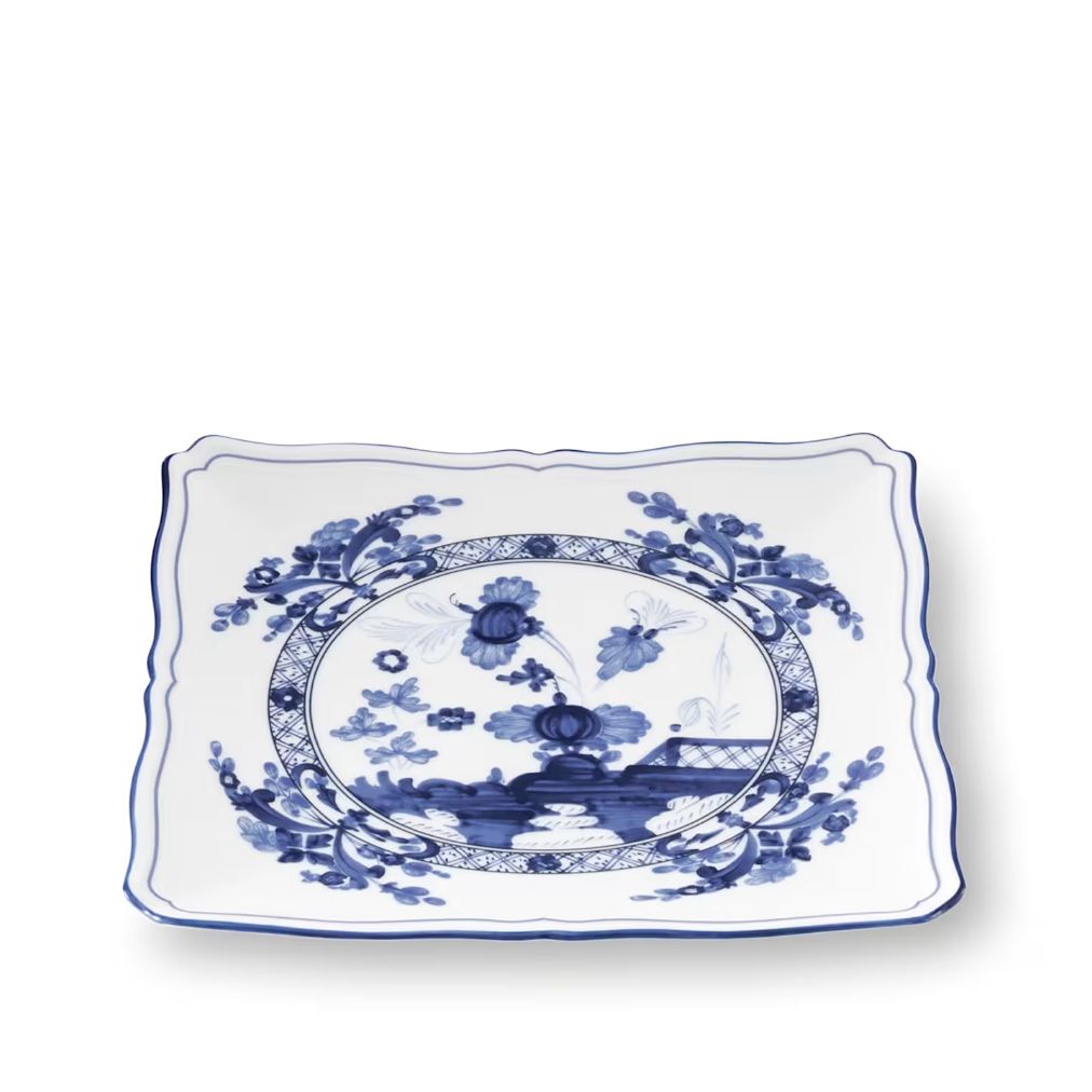 A rectangular white ceramic serving platter with wavy scalloped edges, decorated with a classic blue and white Chinese celadon-style landscape and floral motif in the center.