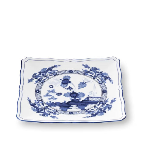 A rectangular white ceramic serving platter with wavy scalloped edges, decorated with a classic blue and white Chinese celadon-style landscape and floral motif in the center.