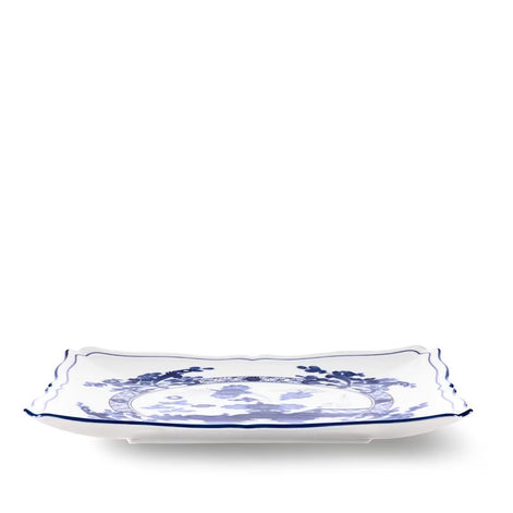 A rectangular white ceramic serving platter with scalloped edges and a blue floral pattern, shown on a clean white background.