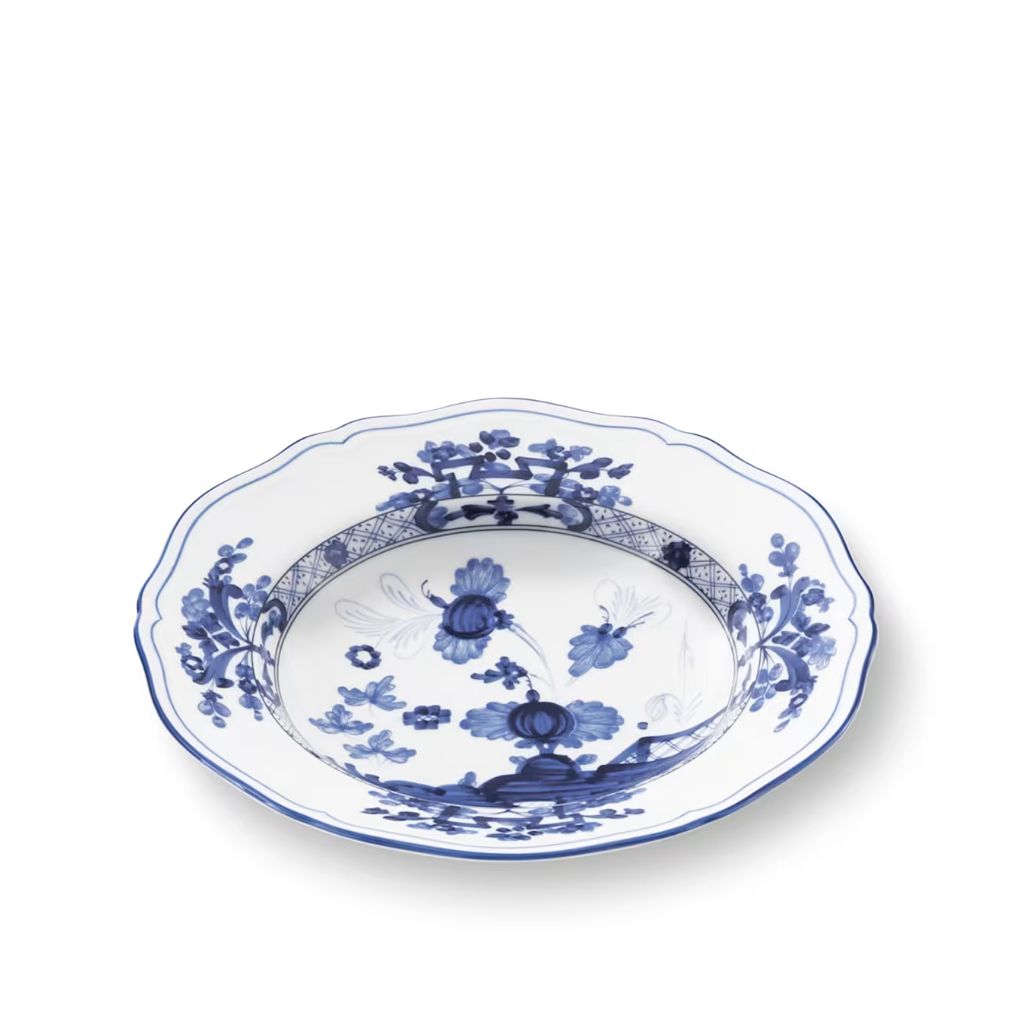 A scalloped ceramic bowl with a blue and white floral pattern, photographed from an elevated angle on a white background.