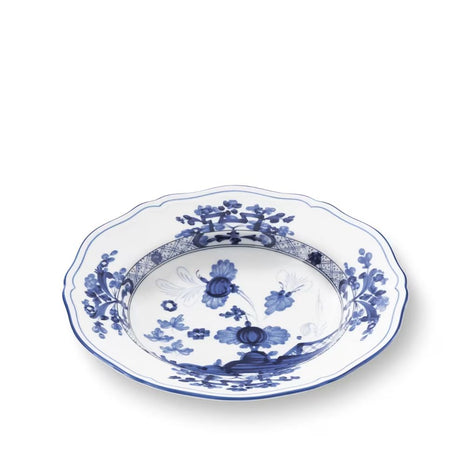 A scalloped ceramic bowl with a blue and white floral pattern, photographed from an elevated angle on a white background.