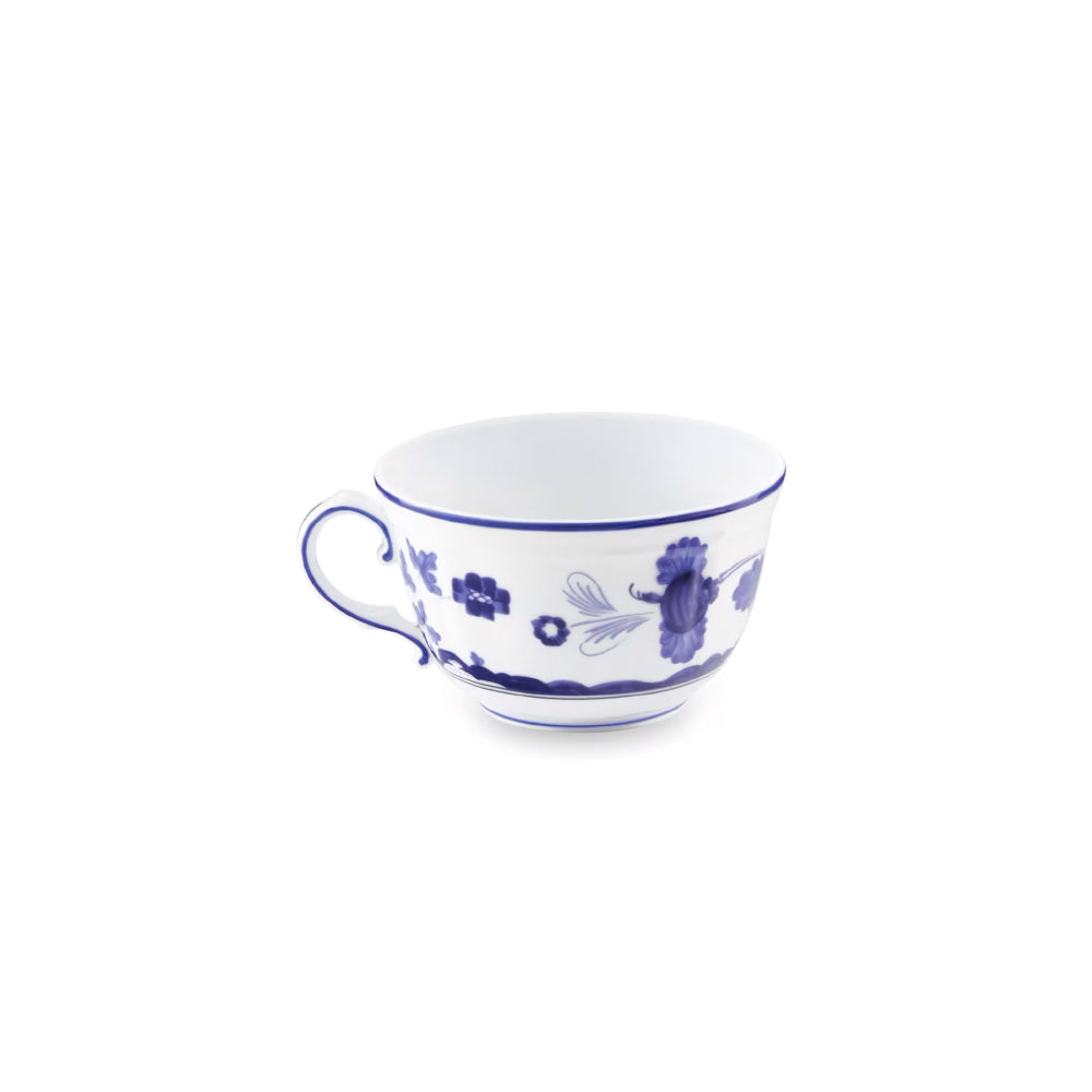A white ceramic teacup with a blue floral and bird pattern, shown against a plain white background.