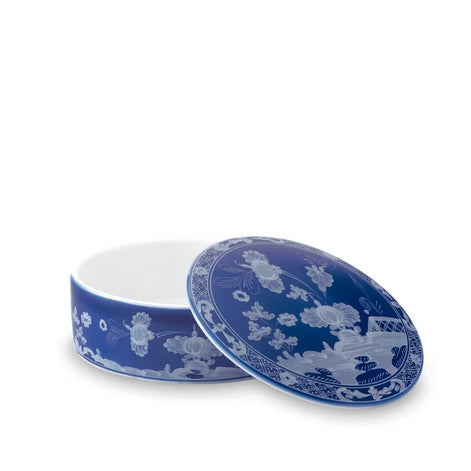 A round ceramic lidded box with a deep cobalt blue and white floral pattern, shown with the lid propped open on a white background.