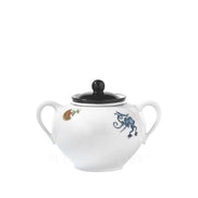 A white ceramic sugar bowl with two side handles, a black lid, and decorative blue and gold illustrations, shown on a plain white background.