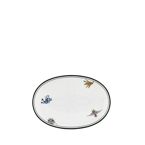 An oval white ceramic serving platter with a black rim, decorated with three small hand-painted floral and leaf motifs in blue, gold, and brown, set against a solid white background.