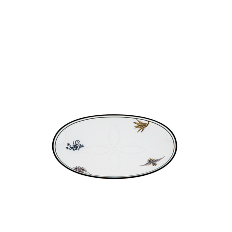 An oval white ceramic plate with a black rim, decorated with small hand-painted floral motifs in gold and blue, shown on a plain white background.
