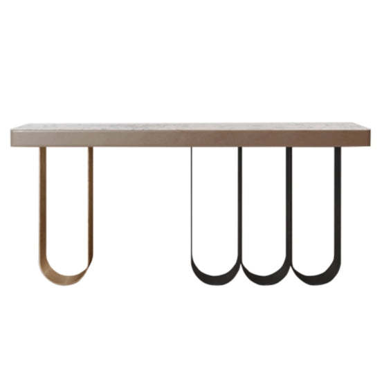 Defined by a sleek marble top resting on a rhythmic composition of slender looped metal legs, Iris transforms a functional silhouette into a sculptural statement. The airy U-shaped bases — rendered in contrasting dark and brushed gold finishes — create a sense of weightlessness and movement beneath the solid stone surface. Noble materials including marble and metal are brought together with balance and precision, reflecting Medea's commitment to harmonious design and meticulous artisan execution.