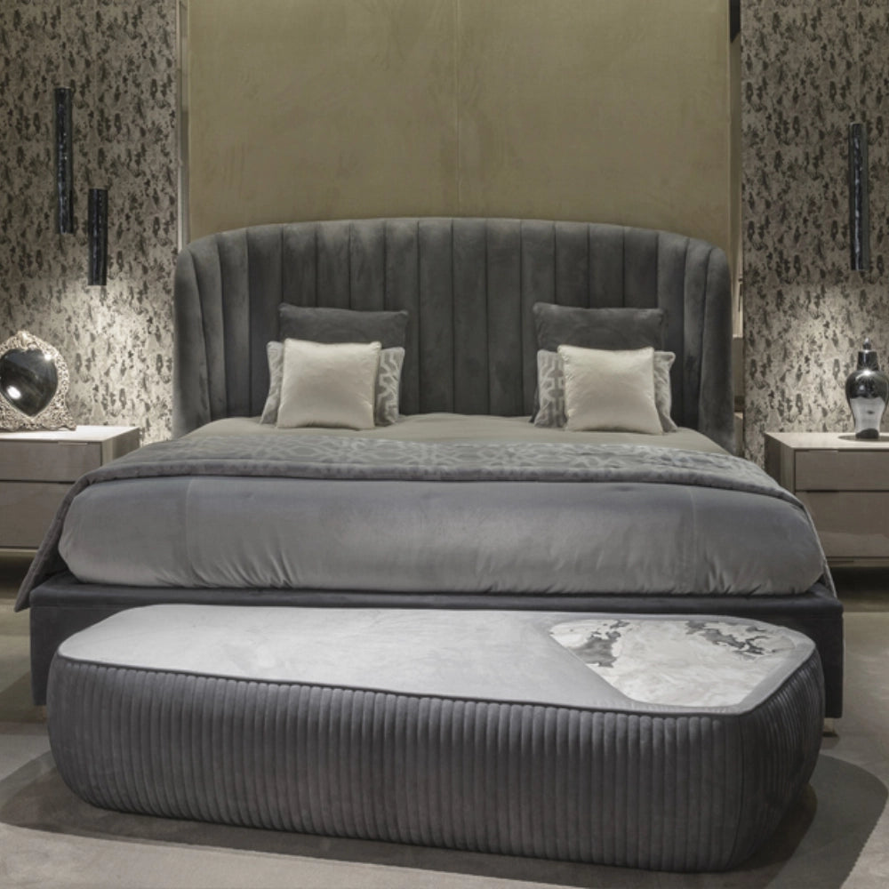 The Empire Bed by Medea 1905 embodies the essence of contemporary Italian living through refined craftsmanship, enveloping volumes, and luxurious materiality. Its signature wingback headboard, defined by elegant vertical channel stitching, rises in a graceful curve that gently wraps the sleeping area, creating a sense of intimacy