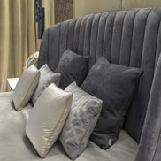 The Empire Bed by Medea 1905 embodies the essence of contemporary Italian living through refined craftsmanship, enveloping volumes, and luxurious materiality. Its signature wingback headboard, defined by elegant vertical channel stitching, rises in a graceful curve that gently wraps the sleeping area, creating a sense of intimacy