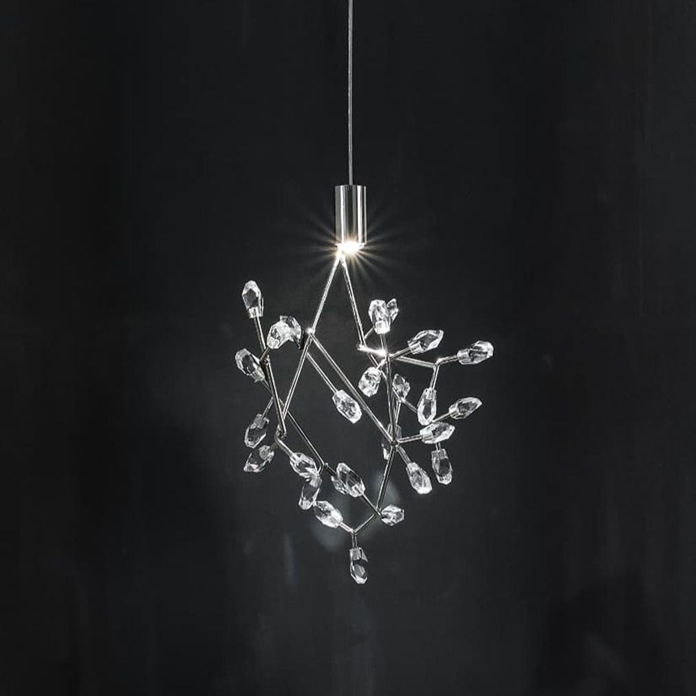 A modern pendant light with a clear crystal branch-like structure suspended from a slim silver metal rod against a dark background.