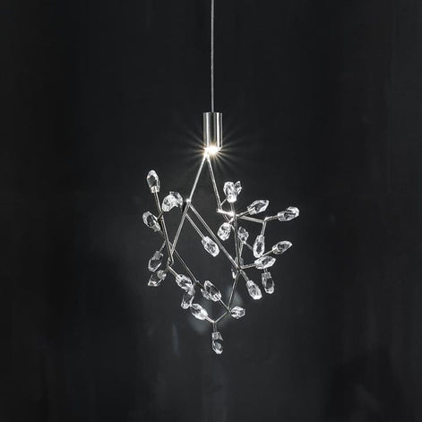 A modern pendant light with a clear crystal branch-like structure suspended from a slim silver metal rod against a dark background.