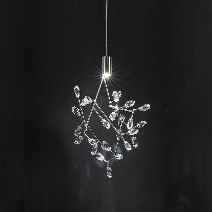 A modern pendant light with a clear crystal branch-like structure suspended from a slim silver metal rod against a dark background.