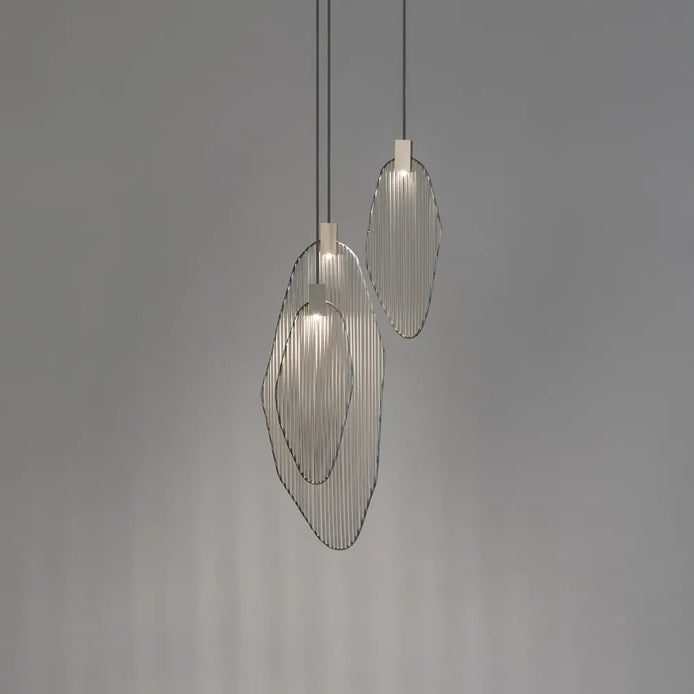 Three silver-tone Terzani Harpe pendants with overlapping oval metal frames and vertical rods, illuminated against a gray background.