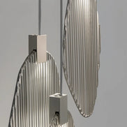 Close-up of overlapping Terzani Harpe pendant frames with polished vertical metal rods and rectangular silver-tone light housings.