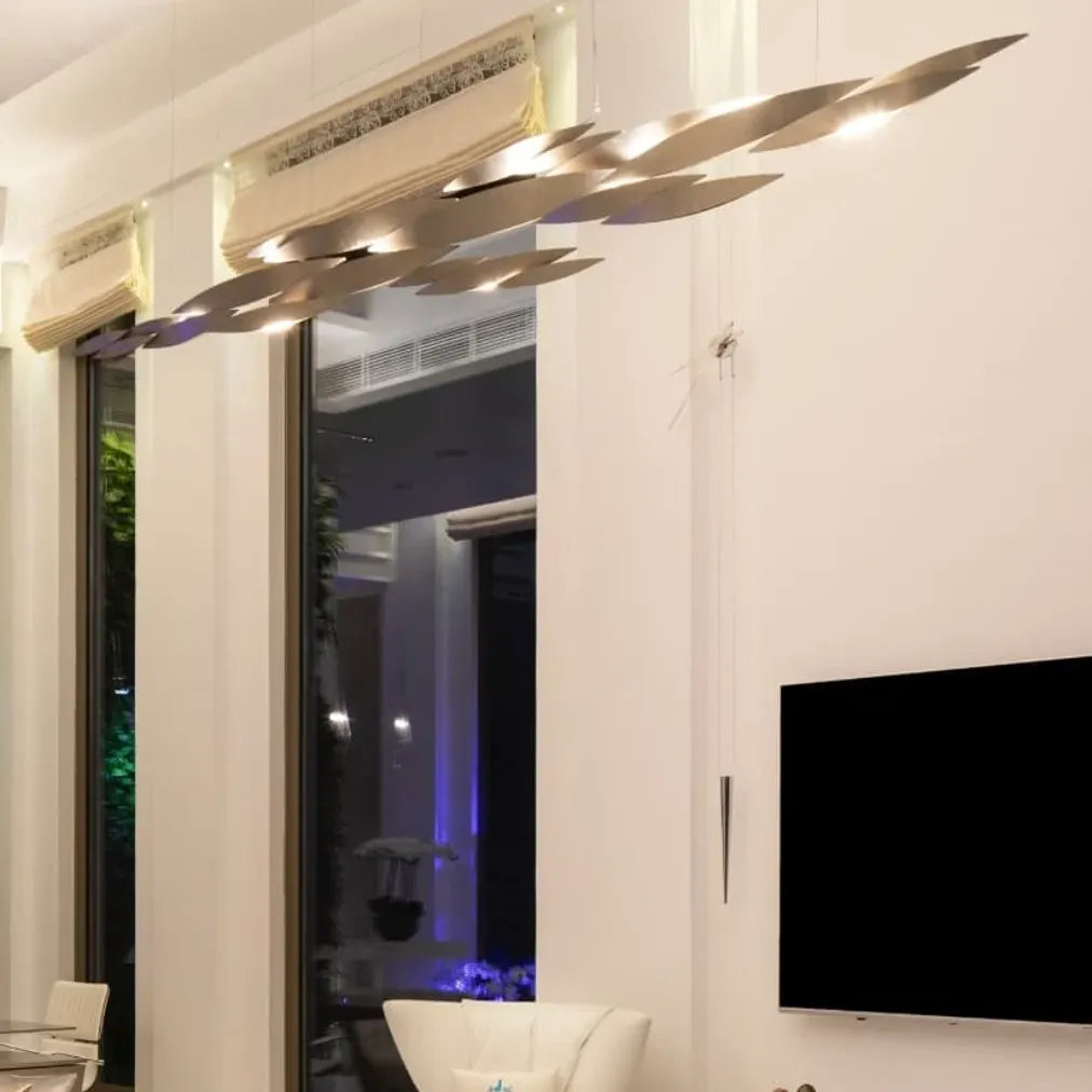 Close-up of silver-tone Terzani I Lucci Argentati chandelier elements showing curved fish-inspired forms and illuminated underside edges.