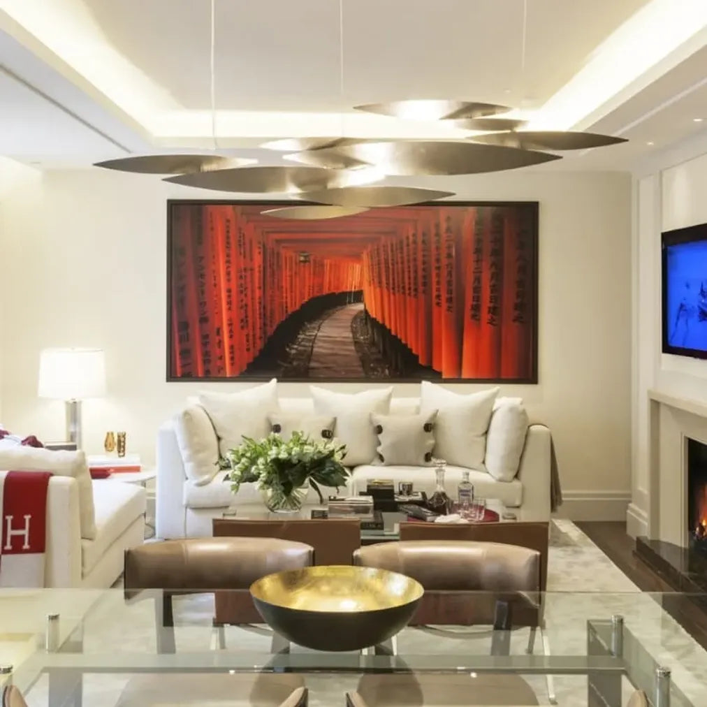 Gold-tone Terzani I Lucci Argentati linear chandelier against a pale background, with overlapping organic light elements on slender suspension cables.