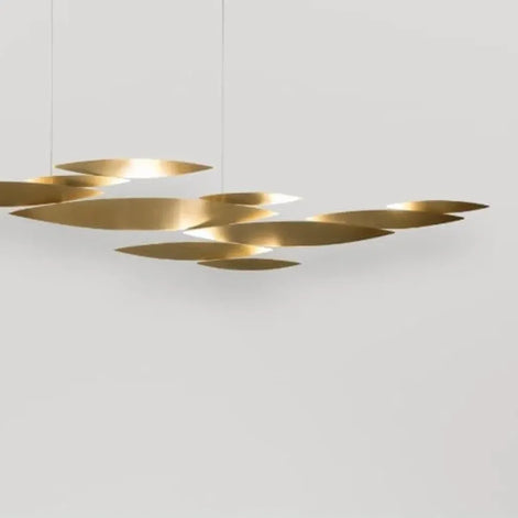 White Terzani I Lucci Argentati linear chandelier above a pale console with stone ornaments, showing its floating organic arrangement.