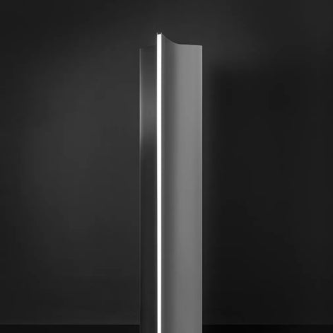 Terzani Stanley floor lamp by Dodo Arslan, showing its sculptural brushed stainless steel body and narrow vertical light diffuser against a dark background.