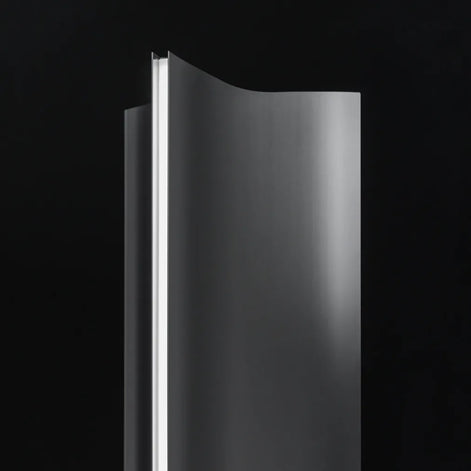 Close-up of the Terzani Stanley floor lamp showing its curved brushed stainless steel panels and satin diffuser forming a bright vertical line of light.