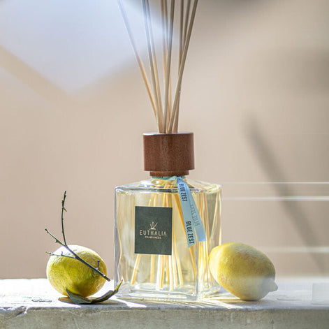 Euthalia fragrance bottle with 'Blue Zest' label and lemon in the background. At Archideco Interior Gallery.